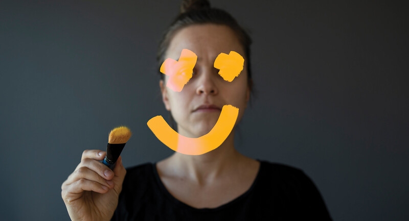November 2021 France Thumbnail Image: A teacher with a smiley face painted over her face.