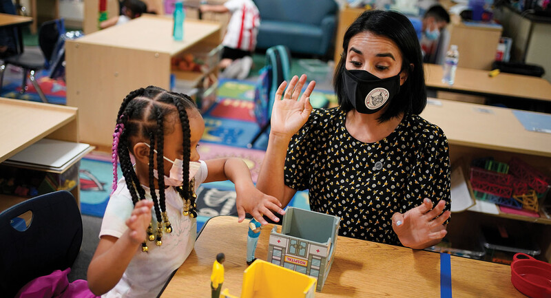 Teacher Juliana Urtubey works with a young student in a class at Kermit R. Booker Sr. Elementary School. Photo Credit goes to AP Photo and John Lochner.