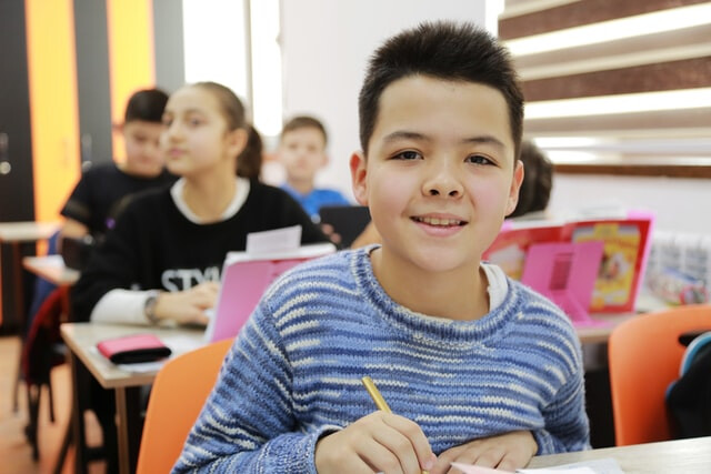 Boy smiling in classroom (thumbnail)